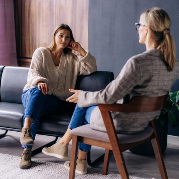 A young woman in a consultation with a professional psychologist listens to advice on improving behavior in life. The modern millennial woman is developing mindfulness and psychological health.